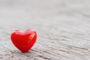 Red heart on wooden plank photo