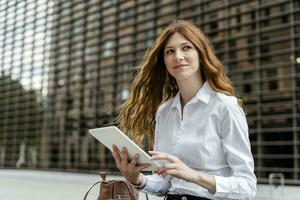 Young businesswoman in the city, using digital tablet photo